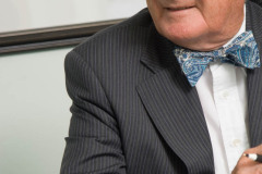 Corporate Photograph of bow-tied man in his late sixities, invol