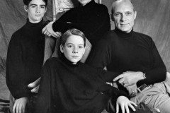 Studio portrait of family dressed in black tops and sitting on a