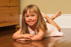 Casual Portrait of a young girl lying on the wooden floor of her