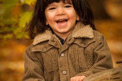 Outdoor portrait of a young boy with shoulder length hair wearin