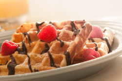 Food photography of waffles on square, clear glass plate, with b